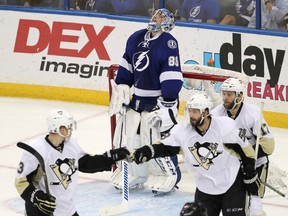 Tampa Bay Lightning goalie Andrei Vasilevskiy, of Russia, looks up as Pittsburgh Penguins defensemen Kris Letang and Olli Maatta, of Finland, congratulate each other during the third period of Game 6. (AP Photo/Brian Blanco)