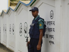 A Bangladeshi police official stands guard in front of a Shiite mosque in Dhaka on November 27 , 2015, after authorities increased security following an attack on a Shiite mosque in Bogra overnight.  At least one man was killed and three others injured as gunmen opened fire on a Shiite mosque in the Shibganj Upazila area of Bogra.  The Islamic State group has claimed responsibility for a deadly attack on worshippers at a Shiite mosque in northern Bangladesh, the US-based monitoring organisation SITE said.  AFP PHOTO/ Munir uz ZAMAN