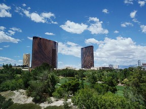 In this May 18, 2016, photo, Wynn and Encore hotel towers rise above the Wynn golf course in Las Vegas. The Paradise Park development proposal unveiled by Wynn Resorts in April is anchored by a 38-acre man-made lake where an 18-hole golf course now sits in Las Vegas. (AP Photo/John Locher)