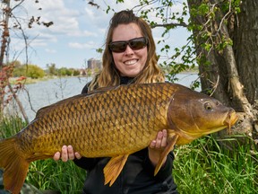 Ashley Rae holds a common carp caught on Lake Ontario in the Kingston area. (Supplied photo)