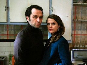 In this image released by FX, Matthew Rhys, left, and Keri Russell appear in a scene from "The Americans." The show will conclude its series run on FX with two more seasons, the network announced Wednesday, May 25, 2016. A 13-episode fifth season will air in 2017, followed by a 10-episode sixth and final season in 2018, FX said.  (Craig Blankenhorn/FX via AP)