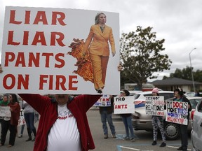 Protesters hold signs outside of a campaign rally for democratic presidential candidate Hillary Clinton at Harrell College on May 25, 2016 in Riverside, Calif. (Justin Sullivan/Getty Images/AFP)