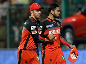Royal Challengers Bangalore captain Virat Kohli (right) is congratulated by his teammate AB De Villiers after he took a catch to dismiss Gujarat Lions batsman Ekalvya Dwivedi during the 2016 Indian Premier League (IPL) Twenty20 first qualifiers cricket match between Royal Challengers Bangalore and Gujarat Lions at The M. Chinnaswamy Stadium in Bangalore on May 24, 2016. (MANJUNATH KIRAN/AFP)