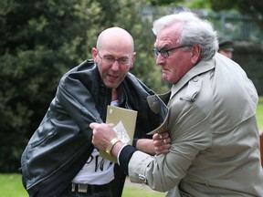 Canadian Ambassador to Ireland Kevin Vickers, right, wrestles with a protester during a State ceremony to remember the British soldiers who died during the Easter Rising at Grangegorman Military Cemetery, Dublin Thursday May 26, 2016.  (Brian Lawless/PA via AP)