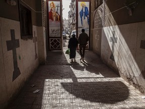 In this Tuesday, Jan. 6, 2015 file photo, Coptic Christians walk outside St. Markos Church in Minya, south of Cairo, Egypt. A Muslim mob ransacked and torched seven Christian homes in a province south of the Egyptian capital, Cairo, after rumors spread that a Christian man had an affair with a Muslim woman, according to a statement by the local Orthodox Coptic church.
Released late Wednesday, it said that during the May 20, 2016 attack, the mother of the Christian man, who had fled the village, was publicly stripped of her clothes by the mob to humiliate her. (AP Photo/Roger Anis, File)