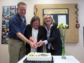 From left, Jim Rennie, Woodlands county mayor, Lana Hatley, executive director for acute care programming and performance for the north zone, and Maryann Chichak, mayor of Whitecourt, perform the official cake cutting at the Whitecourt Healthcare Centre's 50th anniversary.  For more photos of the celebration, see page 27.