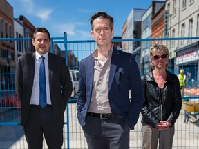 Left to right: James Ward of Rogers & Trainor, Brett Christopher of Kingston Theatre Alliance and Michele Langlois, marketing manager at Downtown Kingston, stand at Bagot and Princess streets in front of the “Big Dig”on April 19 to promote the annual “Kick & Push” theatre festival. (Nick Tardif/For The Whig-Standard)