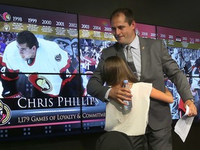 Ottawa Senator Chris Phillips hugs his daughter Zoe during a press conference at Scotiabank Place in Ottawa on May 26, 2016. (Tony Caldwell/Postmedia