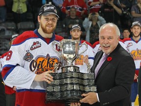 Griffin Reinhart of the Edmonton Oil Kings accepts the MasterCard Memorial Trophy from CHL Commissioner David Branch after the Oil Kings defeated the Guelph Storm in the final of the 2014 MasterCard Memorial Cup at Budweiser Gardens on May 25, 2014 in London, Ontario, Canada. (Claus Andersen/Getty Images/AFP)