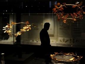 A visitor looks at antiquites at the National Archaeological museum in Athens in this March 18, 2012 file photo. A gold crown (not pictured) from ancient Greece believed to date back to about 300 BC was found at an English cottage. AFP PHOTO/ARIS MESSINIS