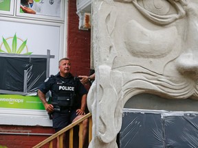 A police officer at Cannawide, a pot dispensary in Kensington Market in Toronto during a raid on the store on Thursday May 26, 2016. Michael Peake/Toronto Sun/Postmedia Network