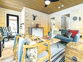 Measuring 450 sq. ft., the structure took several weeks to build including surveying, planning, ordering lumber and construction. Inside is furnished with a mix of grey upholstery, wooden chairs and a back rocker with a large chevron toss pillow.