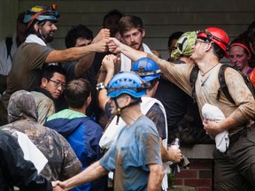 People who were rescued from Hidden River Cave celebrate on Thursday, May 26, 2106, after 18 people on a cave tour were trapped due to flash flood waters in Horse Cave, Kentucky. (AP Photo/Daily News, Austin Anthony)