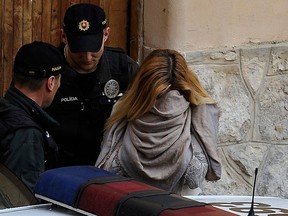 Police officers escort a Slovakian model Mayka Marica Kukucova (R) from court in Trencin, April 10, 2014. REUTERS/Radovan Stoklasa