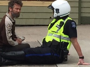 Twitter photo of  Halifax officer Const. Shawn Currie chatting with a busker has gone viral. (Twitter.com/BrunoBaurin)