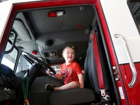 Emily Mountney-Lessard/The Intelligencer
Four-year-old Pierce Jackson sits on the back of a firetruck with Prince Edward County firefighter Brent Lucas on Friday.