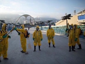 In this Jan. 26, 2016  file photo, health workers get ready to spray insecticide to combat the Aedes aegypti mosquitoes that transmits the Zika virus, under the bleachers of the Sambadrome in Rio de Janeiro, which will be used for the Archery competition in the 2016 summer games. (AP Photo/Leo Correa, File)