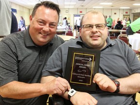 Sarnia McDonald's employee Casey Marshall poses with franchise owner Peter Buckley Friday after presenting Buckley with this year's Community Living Sarnia-Lambton Hero Award. Buckley and his wife Colleen, both honoured with the award, have employed people with disabilities in Sarnia for the past 15 years. (Tyler Kula/Sarnia Observer/Postmedia Network)