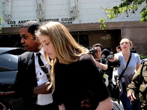 Actress Amber Heard leaves Los Angeles Superior Court court on Friday, May 27, 2016, after giving a sworn declaration that her husband Johnny Depp threw her cellphone at her during a fight Saturday, striking her cheek and eye. The judge ordered Depp to stay away from his estranged wife and ruled that Depp shouldn't try to contact Heard until a hearing is conducted on June 17. Heard filed for divorce on Monday. (AP Photo/Richard Vogel)