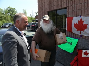Jason Miller/ The Intelligencer
Prince Edward-Hastings MPP Todd Smith talks to Robert Hertendy, who donated several bags and boxes of being packed for a truck ride to Alberta next week in support of Fort McMurray evacuees.
