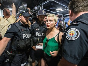 A protester is asked to leave after interrupting press conference where Police Chief Mark Saunders spoke about Thursday's pot shop raids. (CRAIG ROBERTSON, Toronto Sun)