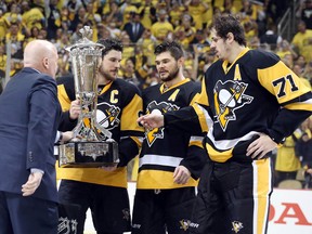NHL deputy commissioner Bill Daly (left) presents the Prince of Wales trophy to Pittsburgh Penguins Chris Kunitz, Sidney Crosby and Evgeni Malkin after they beat the Tampa Bay Lightning to win the Eastern Conference championship Thursday at the CONSOL Energy Center. (Charles LeClaire/USA TODAY Sports)