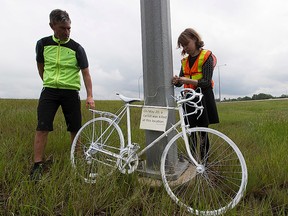 Jonathan Woelber and Coreen Shewfelt  from the Edmonton Bicycle Commuters Society installs a Ghost Bike Memorial on Highway 14 just east of the Anthony Henday overpass on May,  27 2016 near Edmonton. On Friday May 20th, a cyclist was tragically killed after being struck by a car southeast of Edmonton. The driver of the car has been charged with dangerous operation of a motor vehicle causing death, and refusing to provide a breath sample.