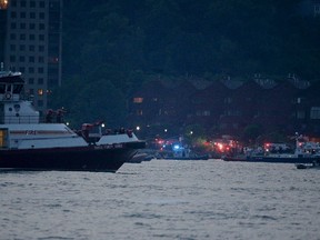 Search and rescue boats look for a small plane that went down in the Hudson River, Friday, May 27, 2016. The Federal Aviation Administration say it received a report a World War II vintage P-47 Thunderbolt aircraft may have gone down in the river 2 miles south of the George Washington Bridge. (AP Photo/Julie Jacobson)