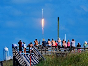 Crowds pack the Canaveral National Seashore Friday, May 27, 2016, to witness the liftoff of a SpaceX Falcon 9 rocket with the THAICOM-8 satellite aboard, from Launch Complex 40 at the Cape Canaveral Air Force Station. (Craig Rubadoux/Florida Today via AP)