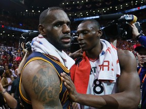 Toronto Raptors centre Bismack Biyombo (8) gives a congratulatory hug to Cleveland Cavaliers star LeBron James after Game 6 of the Eastern Conference final in Toronto Friday February 26, 2016. (Stan Behal/Toronto Sun/Postmedia Network)