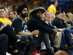 "Super fan" Nav Bhatia and NHLer P.K. Subban watch the Raptors-Calvaiers game from their courtside seats in the third quarter in Cleveland on May 18, 2016. (Jack Boland/Toronto Sun/Postmedia Network)