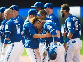 Toronto Blue Jays second baseman Devon Travis (29) is congratulated by teammates after driving in the game-winning run against the Boston Red Sox in Toronto on Saturday, May 28, 2016. (THE CANADIAN PRESS/Nathan Denette)