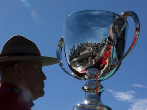 A RCMP officer stands next to the Grey Cup as the CFL announces Thursday October 1, 2015 that Toronto will host the 2016 Grey Cup. (Dave Abel/Toronto Sun/Postmedia Network)