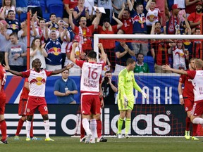 New York Red Bulls forward Bradley Wright-Phillips, left, celebrates after scoring his second goal of the first half against Toronto FC goalkeeper Clint Irwin, third from right, during an MLS soccer game on Saturday in Harrison, N.J. (AP Photo/Adam Hunger)