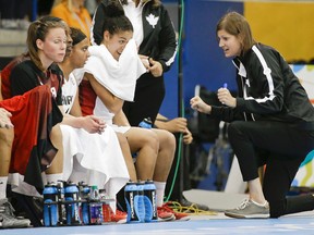 Canada head coach Lisa Thomaidis, right, talks with her players in the first half of a women's preliminary round basketball game against Venezuela at the Pan Am Games Thursday, July 16, 2015, in Toronto. Canada won 101-38. (AP Photo/Mark Humphrey)