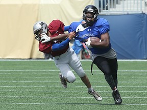 Keiran Buskell of Team Bramwell (right), from the Daniel Mac Maroons, stiff-arms Team Miller DB Mahesh Sewpaul of the Maples Marauders during the Winnipeg High School Football League Senior Bowl at Investors Group Field in Winnipeg on Sat., May 28, 2016. Kevin King/Winnipeg Sun/Postmedia Network