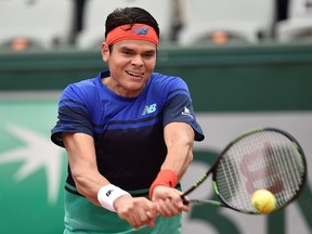 Canada's Milos Raonic returns the ball to Spain's Albert Ramos-Vinolas during their men's fourth round match at the Roland Garros 2016 French Tennis Open in Paris on May 29, 2016. / AFP PHOTO / Eric FEFERBERG