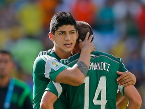 In a June 29, 2014 file photo, Mexico's Alan Pulido consoles teammate Javier Hernandez (14) after the Netherlands defeated Mexico 2-1 during the World Cup round of 16 soccer match between the Netherlands and Mexico at the Arena Castelao in Fortaleza, Brazil. (AP Photo/Eduardo Verdugo, File)