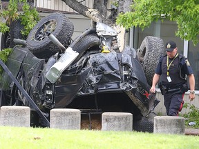 A Winnipeg Police officer examines a truck involved in a fatal single vehicle crash on Corydon Avenue in Winnipeg, Man. Sunday, May 29, 2016. (Brian Donogh/Winnipeg Sun/Postmedia Network)