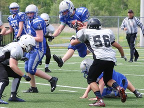 Brad Patterson, middle, of the Sudbury Gladiators junior varsity team, leaps in the air as he is tackled by Oakville Titans defenders during football action at the James Jerome Sports Complex in Sudbury, Ont. on Saturday May 28, 2016. John Lappa/Sudbury Star/Postmedia Network