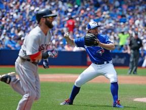 Pitcher R.A. Dickey of the Blue Jays fields Dustin Pedroia's hit and throws him out as Jays host the Boston Red Sox at the Rogers Centre in Toronto on May 29, 2016. (Michael Peake/Toronto Sun/Postmedia Network)
