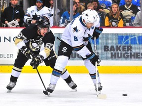 Sidney Crosby of the Pittsburgh Penguins reaches for the puck with Joe Pavelski of the San Jose Sharks during the game at Consol Energy Center in Pittsburgh on Nov. 19, 2015. (Matt Kincaid/Getty Images/AFP)