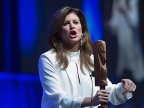 Interim Conservative leader Rona Ambrose holds an aboriginal talking stick as she addresses the audience at the Conservative Party of Canada convention in Vancouver, Friday, May 27, 2016. THE CANADIAN PRESS/Jonathan Hayward