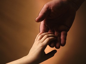 An adult and a child hold hands. (Getty Images)