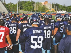 Josh Bourke and the Argos huddle around Scott Milanovich at yesterday’s camp opening in Guelph. (Toronto Argonauts photo)