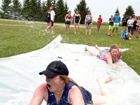 Maggie McDonnell (foreground) and Krista Rock, senior students at Mitchell District High School (MDHS), hit the slip ‘n slide last Wednesday, May 25 at the high school Carnival. Proceeds from the event, $4,400 at press time with a goal of $5,000, will be donated to Michelle Seigner, a Mitchell woman who was seriously injured in a car accident in January.  GALEN SIMMONS MITCHELL ADVOCATE