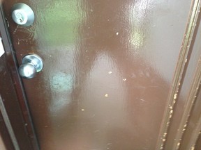 Holes can be seen in the door of a First Ave. home after it was shot at and a cat was mortally wounded. (Kevin Connor/Toronto Sun)