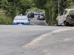 The burned car belonging to slain 22-year-old student Sara Di Pietrantonio is seen along a street in the outskirts of Rome, Monday, May 30, 2016. According to Italian police, Sara, whose body was found close to the car, has been burned alive by her ex-boyfriend as she was was trying to escape from him. (Massimo Percossi/ANSA via AP)
