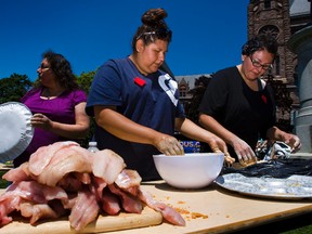 Amanda Swain (right) and Jolene Hookimawillillene (middle) prepare  walleye (from  the waters near their home) to be cooked over a woodfire outside of Queen's Park in Toronto on Wednesday June 6, 2012. The people of Grassy Narrows are still suffering from the debilitating health impacts of mercury poison fifty years after a Dryden mill began dumping 10 tonnes of the neurotoxin into Grassy Narrows’ English-Wabigoon River.