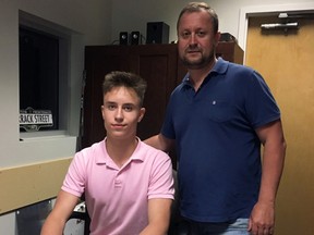 Kingston Frontenacs second-round draft pick Sergey Popov signs his OHL contract while his father, also named Sergey, looks on. (Photo courtesy of Kingston Frontenacs)